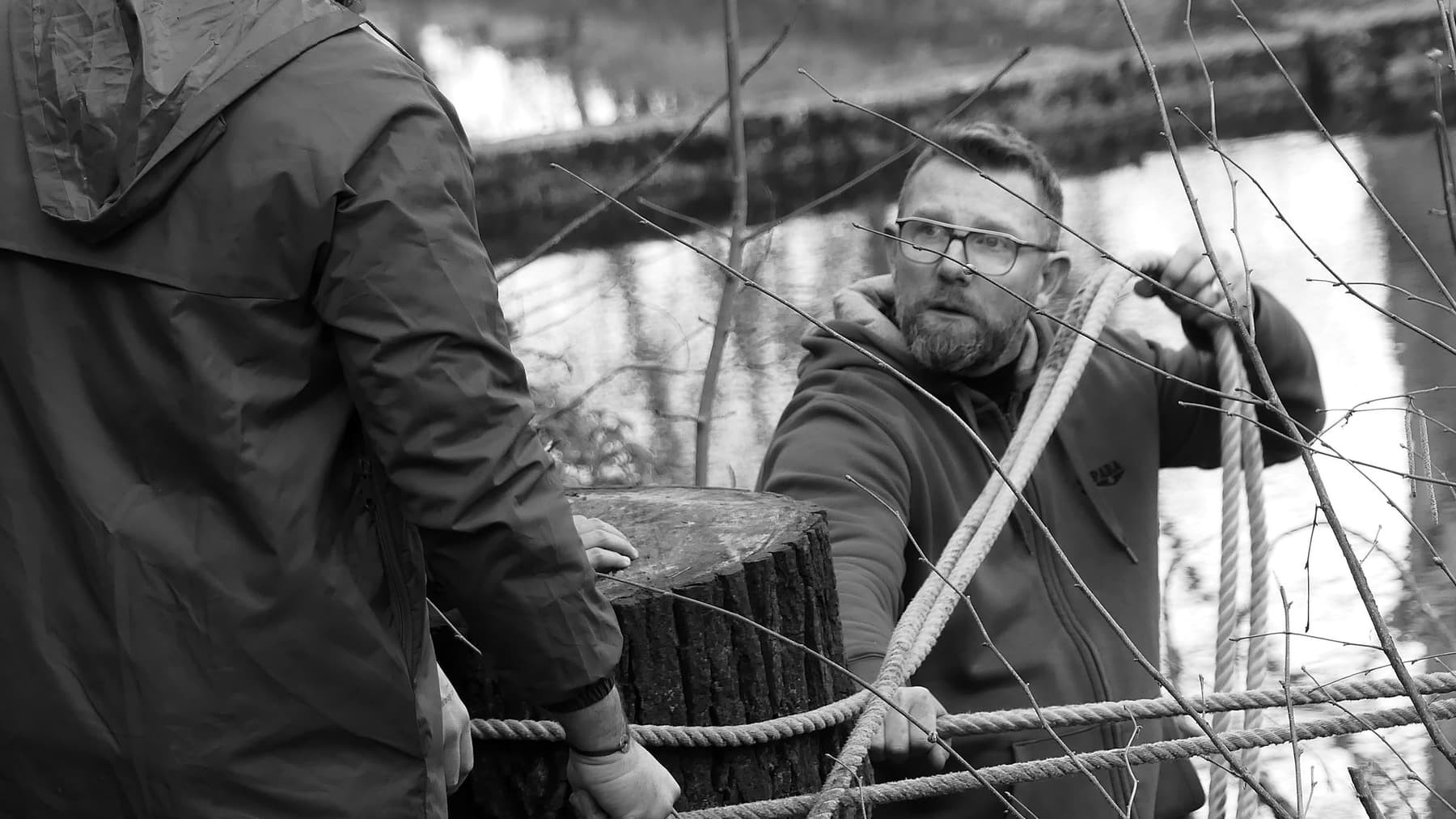 Formateur C4 en noir et blanc, manipulant un cordage lors d'un atelier